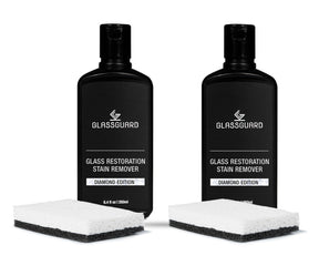 Two bottles of Glassguard Glass Restoration Stain Remover with cleaning sponges