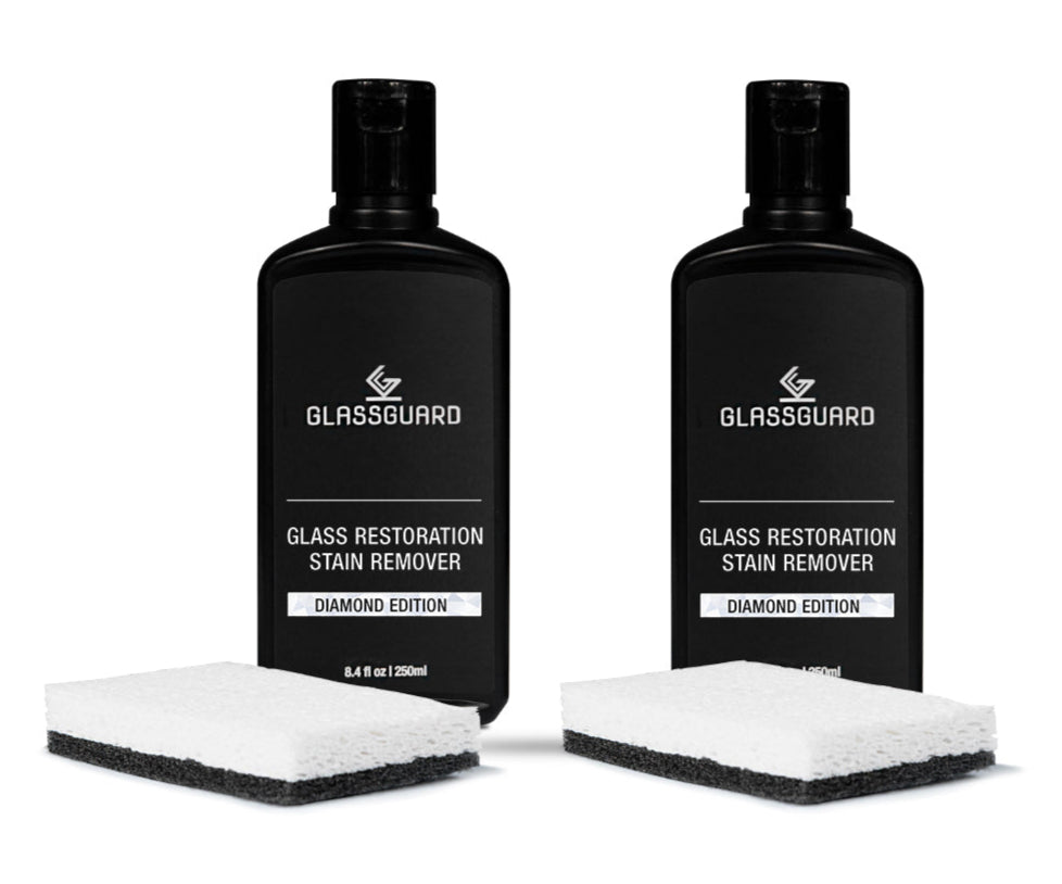 Two bottles of Glassguard Glass Restoration Stain Remover with cleaning sponges