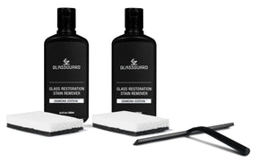 Two bottles of Glassguard Glass Restoration Stain Remover with sponges and a black squeegee
