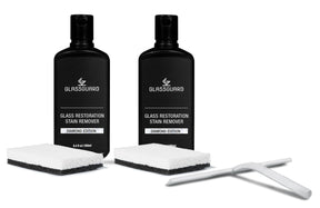 Two bottles of Glassguard Glass Restoration Stain Remover with sponges and a white squeegee